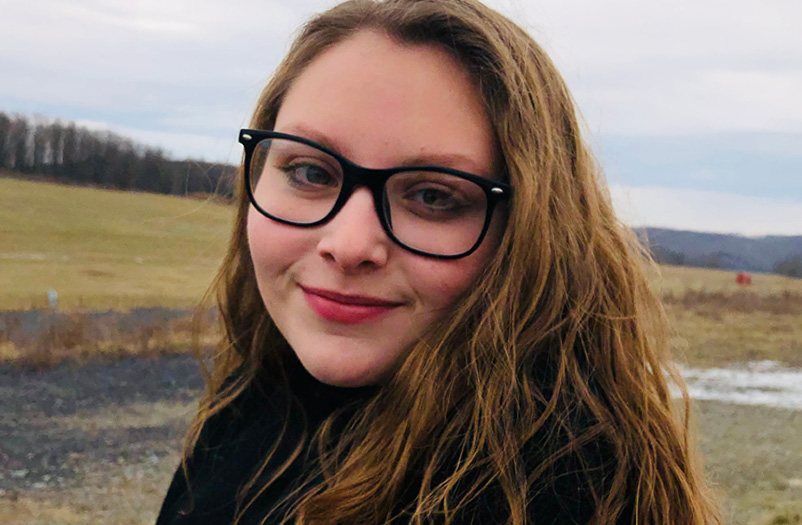 A smiling woman in glasses.